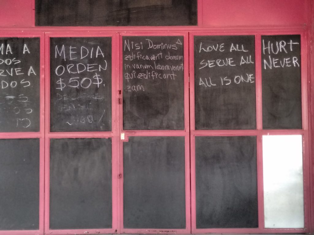 Image of 8 panel chalkboard framed in red with writing in white. One panel reads "HURT NEVER."